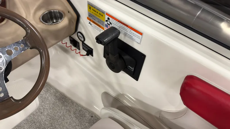 Slide: The Image of Interior of a 2008 Glastron GT 225 boat with controls and warning labels. - 13