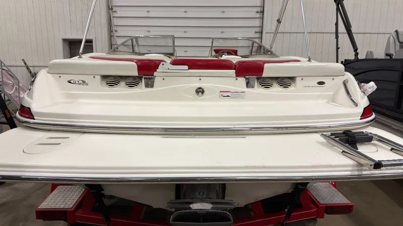 Slide: The Image of Rear view of a 2008 Glastron GT 225 boat in a workshop. - 2