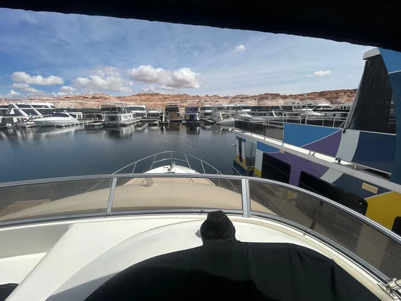 Slide: The Image of View from 2005 Meridian Gone Dingy 411 Sedan, overlooking marina with houseboats and rocky landscape. - 16