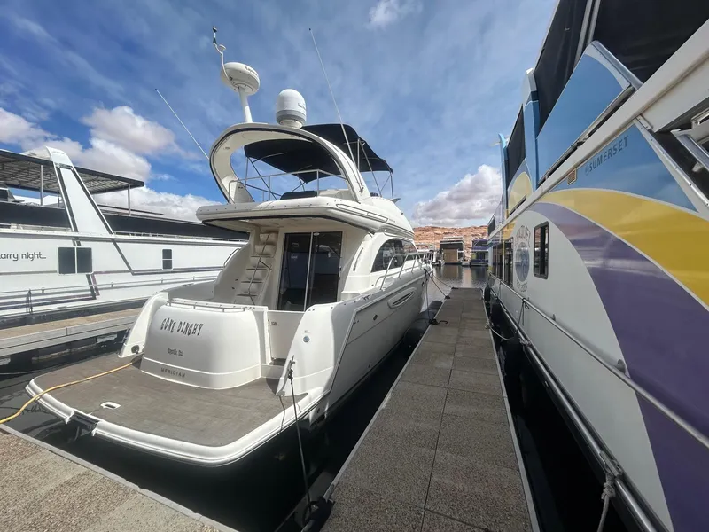 Slide: The Image of 2005 Meridian Gone Dingy 411 Sedan yacht docked beside colorful houseboat. - 3