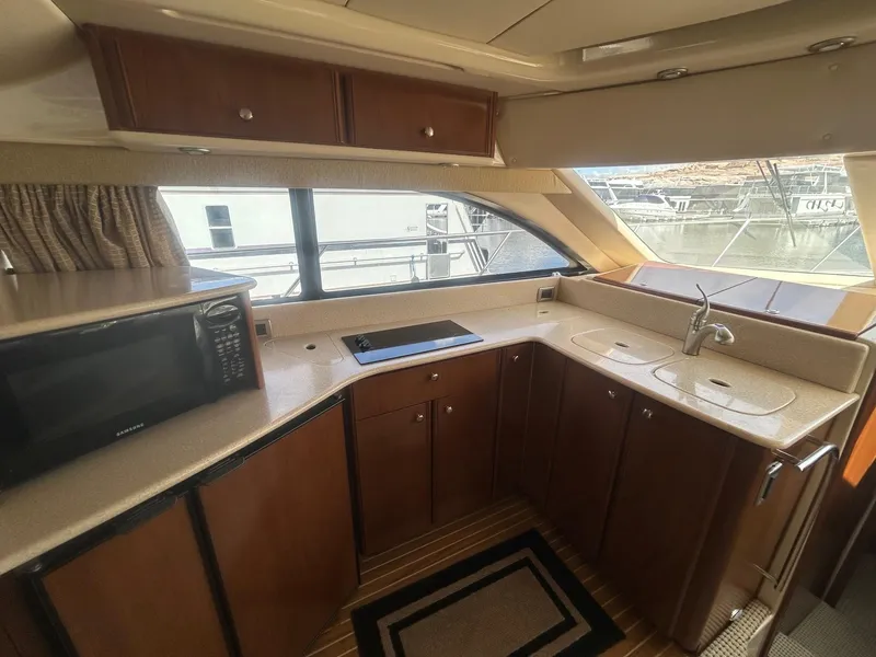 Slide: The Image of 2005 Meridian Gone Dingy 411 Sedan yacht kitchen with wood cabinets and modern appliances. - 7