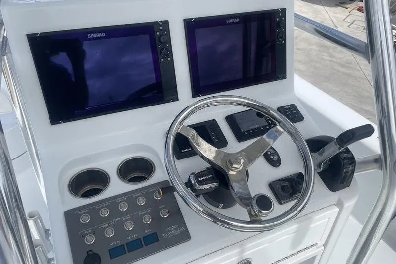 Slide: The Image of Control panel of 2020 Islamorada Boatworks 24 Morada with dual Simrad displays and steering wheel. - 20