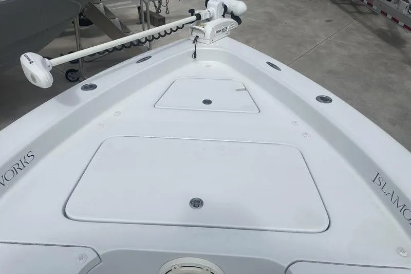 Slide: The Image of 2020 Islamorada Boatworks 24 Morada bow with trolling motor, docked on concrete. - 22