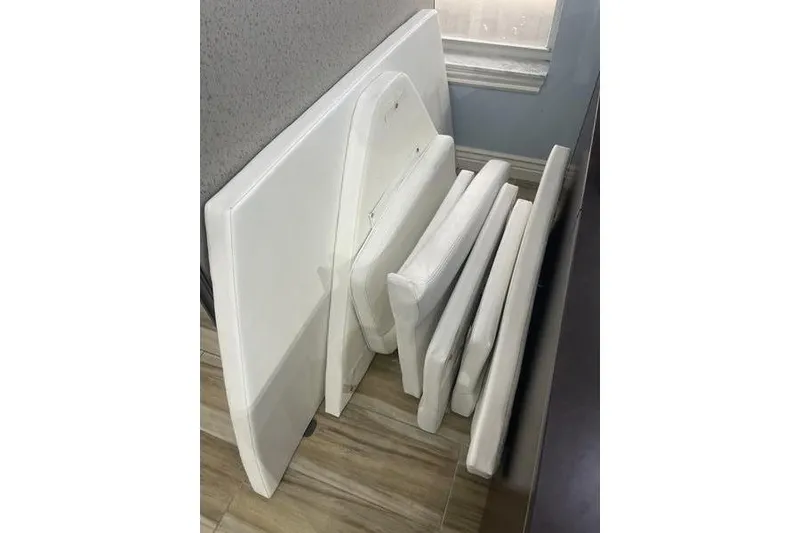 Slide: The Image of White boat cushions for 2020 Islamorada Boatworks 24 Morada, stacked indoors. - 24