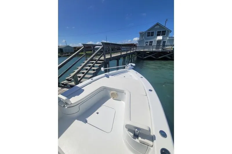 Slide: The Image of 2020 Islamorada Boatworks 24 Morada docked near a wooden pier under a clear blue sky. - 8