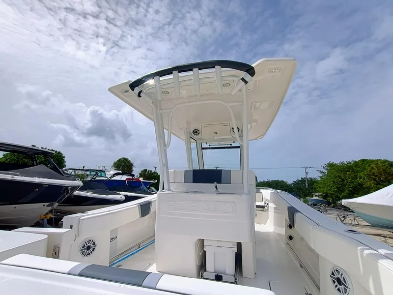 Slide: The Image of 2025 Robalo R270 Center Console boat with T-top, docked under cloudy sky. - 15