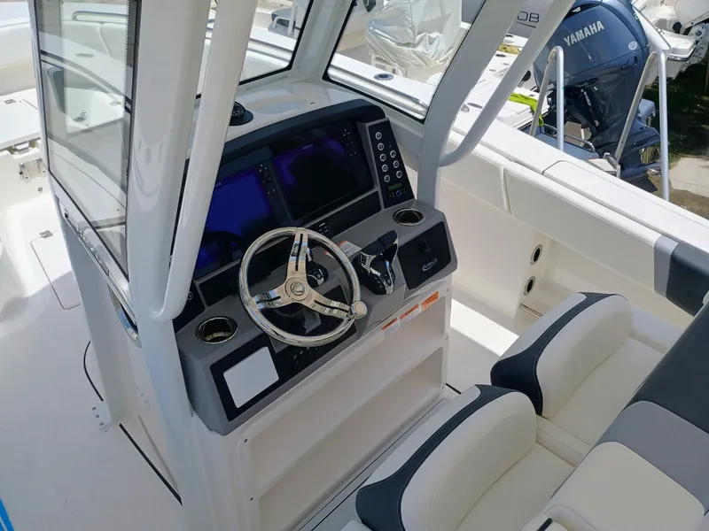 Slide: The Image of 2025 Robalo R270 Center Console boat interior with steering wheel and seating. - 21