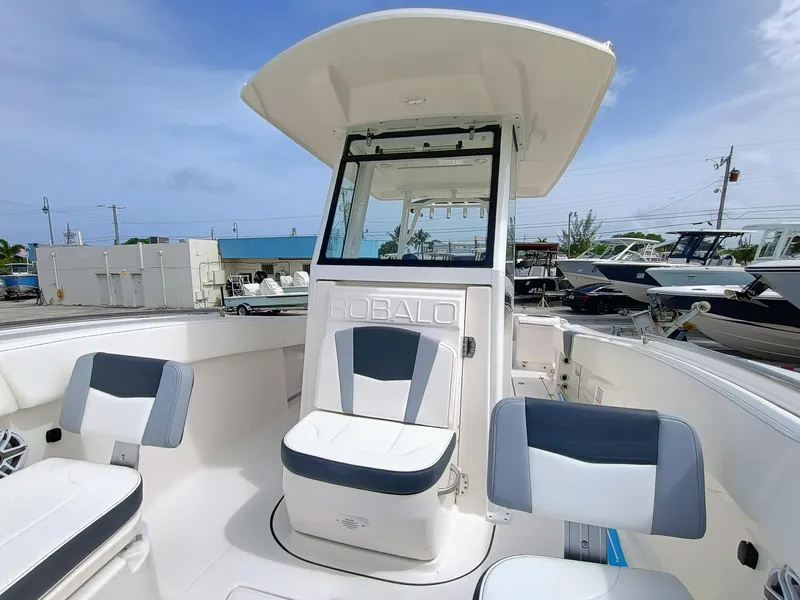 Slide: The Image of 2025 Robalo R270 Center Console boat with seating, docked under clear skies. - 27