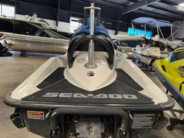 Slide: The Image of 2008 Sea-Doo GTX 155 jet ski in showroom, rear view, surrounded by other watercraft. - 7