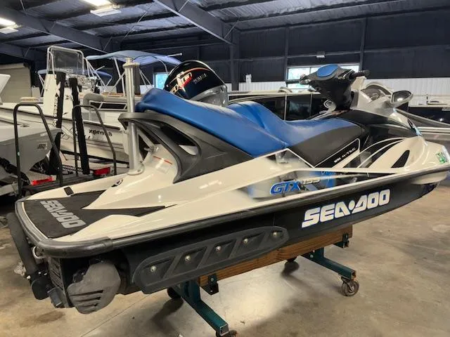 Slide: The Image of 2008 Sea-Doo GTX 155 jet ski in a showroom, featuring blue and white design. - 8