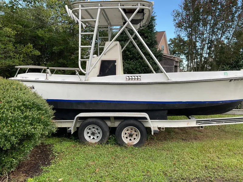 Slide: The Image of 1978 Shamrock 200 cc boat on trailer, parked on grass beside bushes. - 6