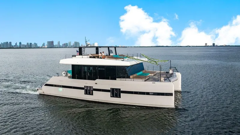 The Image of Luxurious 2018 Sunreef 70 yacht cruising on open water with city skyline backdrop. - 0