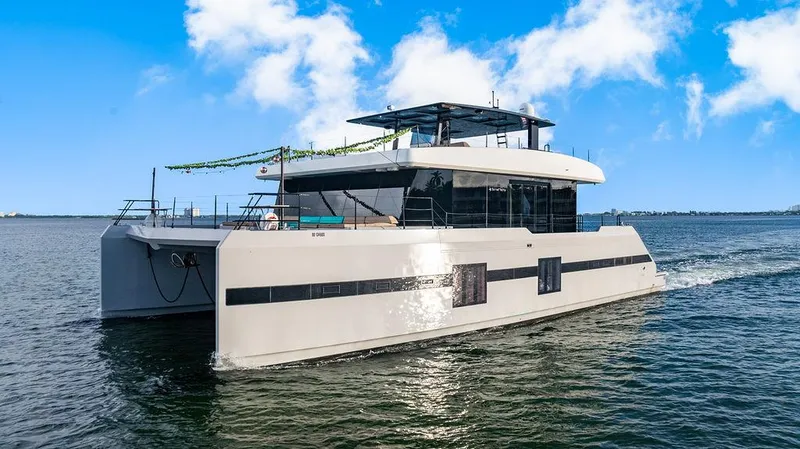 Slide: The Image of Luxurious 2018 Sunreef 70 yacht cruising on open water under a clear blue sky. - 27