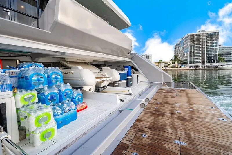 Slide: The Image of Sunreef 70 yacht storage area with water bottles and equipment, docked near waterfront buildings. - 32