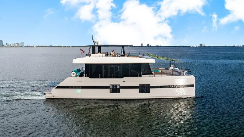 Slide: The Image of Luxurious 2018 Sunreef 70 yacht cruising on open water under a clear blue sky. - 4