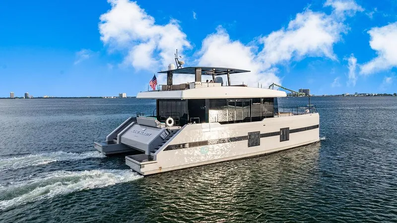 Slide: The Image of Luxury Sunreef 70 yacht cruising on open water under a clear blue sky. - 8