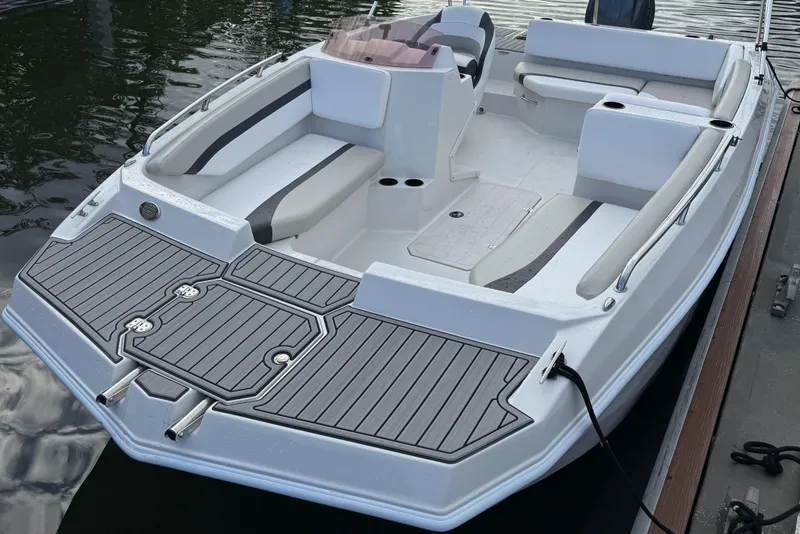 Slide: The Image of 2024 Starcraft SVX 171 OB boat with spacious seating, docked on calm water. - 2
