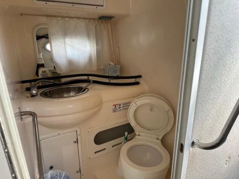 Slide: The Image of 2005 Rinker Fiesta Vee 300 bathroom with sink, toilet, and curtain. - 10