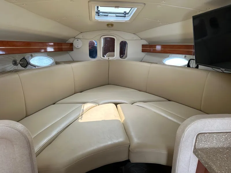 Slide: The Image of Interior of 2005 Rinker Fiesta Vee 300 boat with beige seating and a mounted TV. - 7
