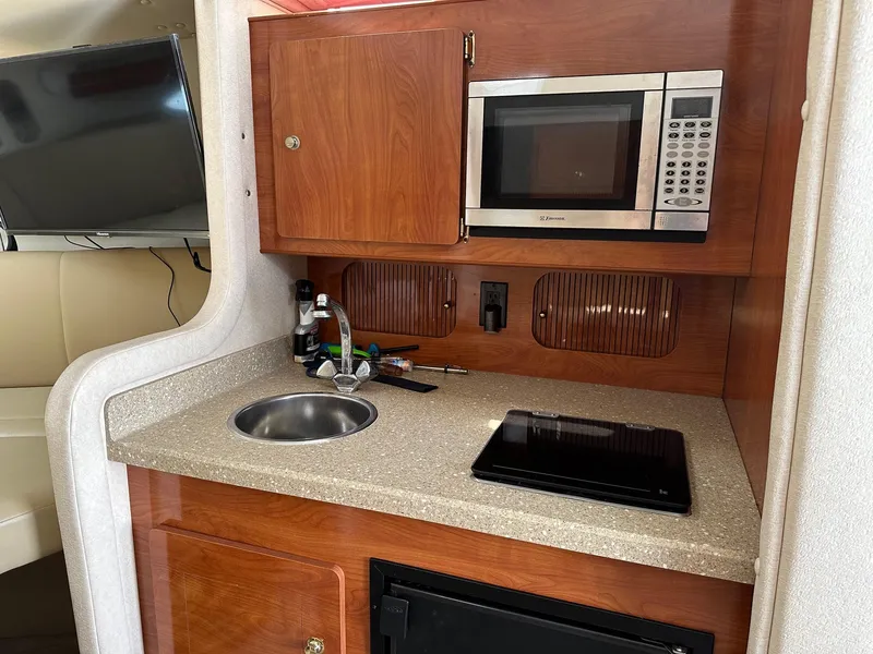 Slide: The Image of 2005 Rinker Fiesta Vee 300 interior kitchen with microwave, sink, and countertop. - 9