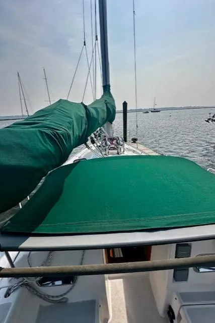 Slide: The Image of Sailboat deck view with green cover, Freedom 35 model, 1998, on calm water. - 14
