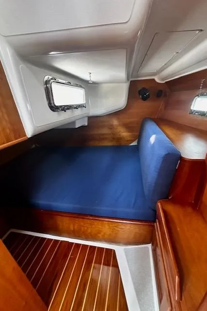 Slide: The Image of Cozy cabin interior of 1998 Freedom 35 sailboat with blue bedding and wooden finish. - 4
