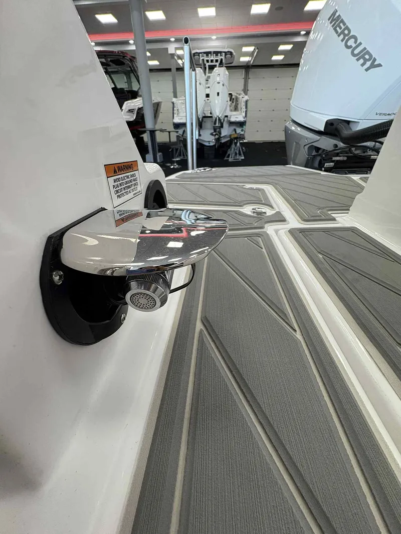 Slide: The Image of 2026 Monterey M65 boat deck with chrome hardware and Mercury engine in showroom. - 11
