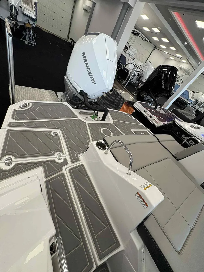 Slide: The Image of 2026 Monterey M65 boat with Mercury engine, featuring sleek deck design in showroom. - 12