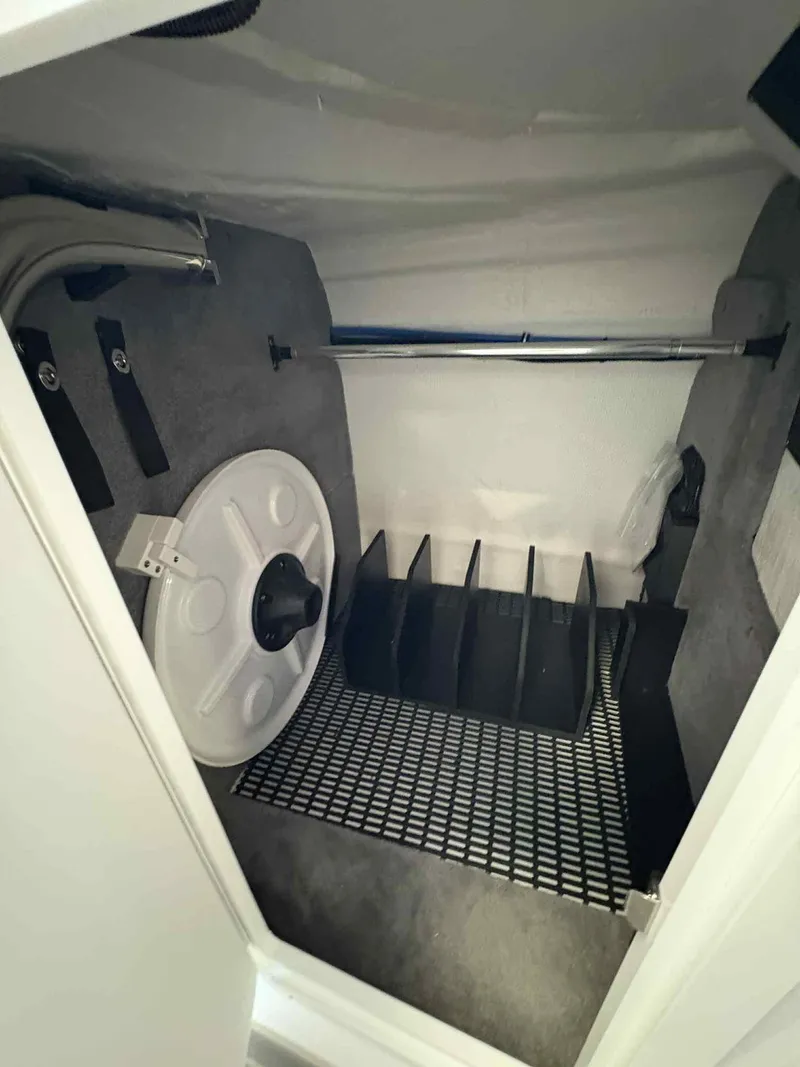 Slide: The Image of Storage compartment in a 2026 Monterey M65 boat, featuring organized shelving and equipment. - 19
