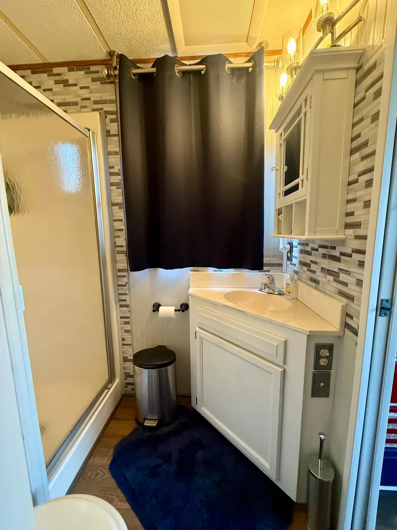 Slide: The Image of Bathroom interior of a 1996 Jamestowner houseboat with shower, vanity, and modern decor. - 11