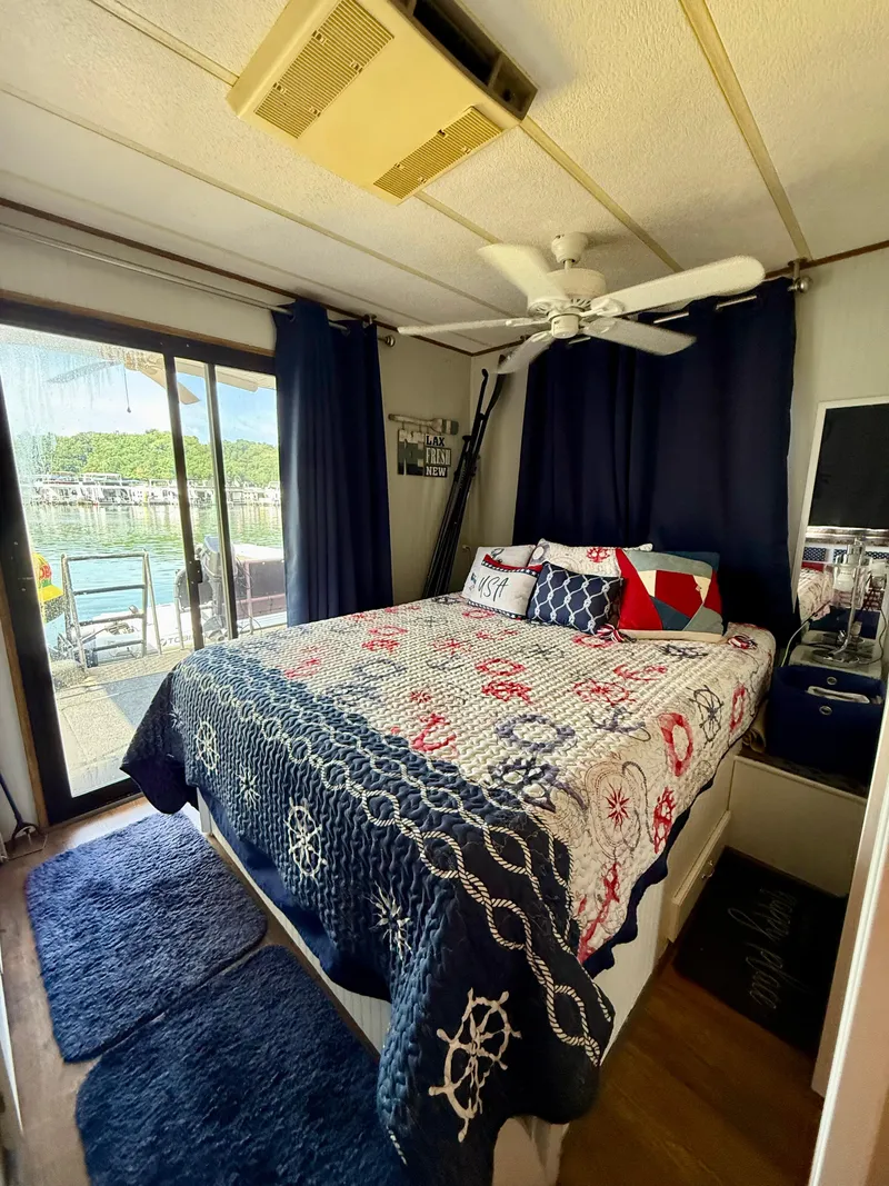 Slide: The Image of Cozy bedroom in 1996 Jamestowner houseboat with nautical-themed decor and lake view. - 14