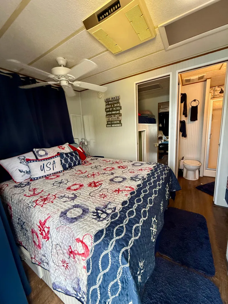 Slide: The Image of Cozy bedroom in a 1996 Jamestowner houseboat with nautical-themed decor. - 15