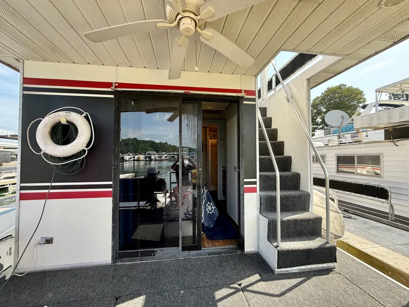 Slide: The Image of 1996 Jamestowner houseboat with stairs, life preserver, and sliding glass door on deck. - 16