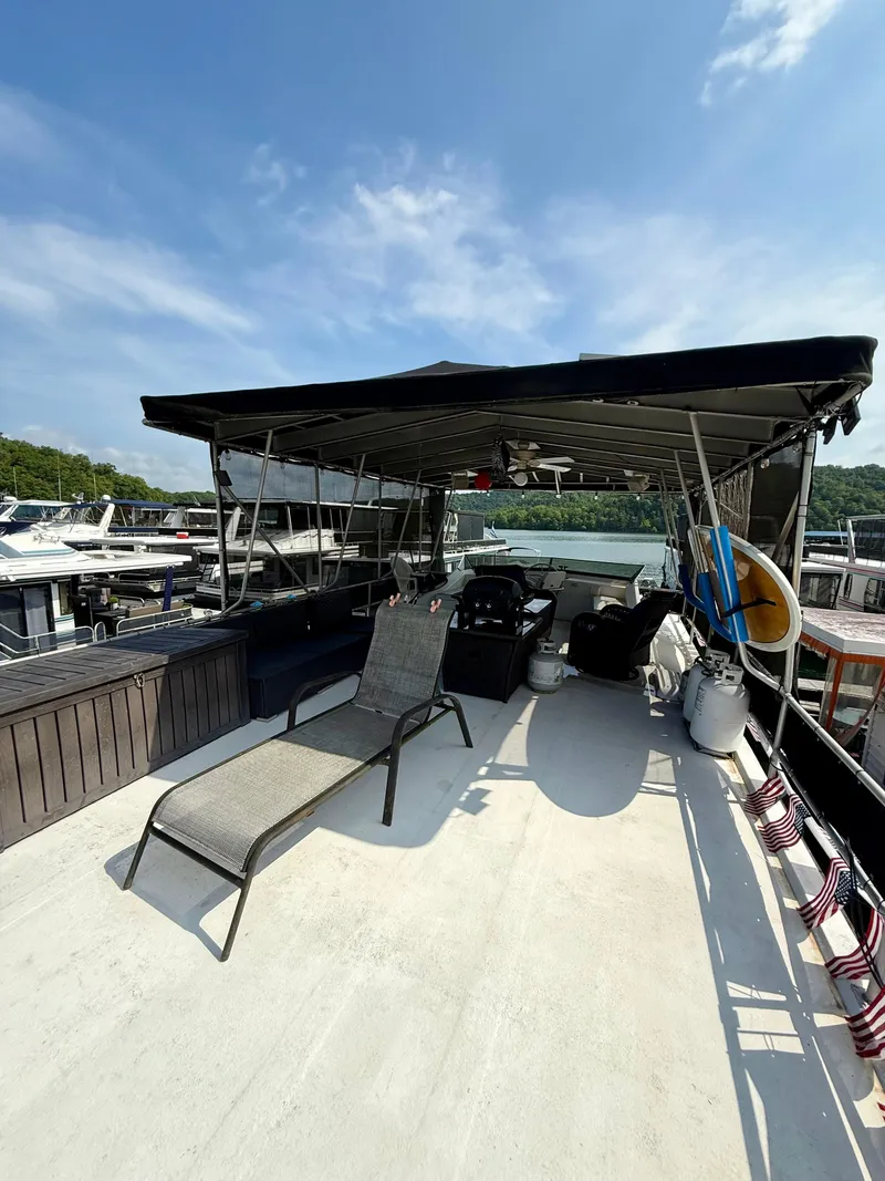 Slide: The Image of 1996 Jamestowner houseboat deck with lounge chair, canopy, and scenic marina view. - 18