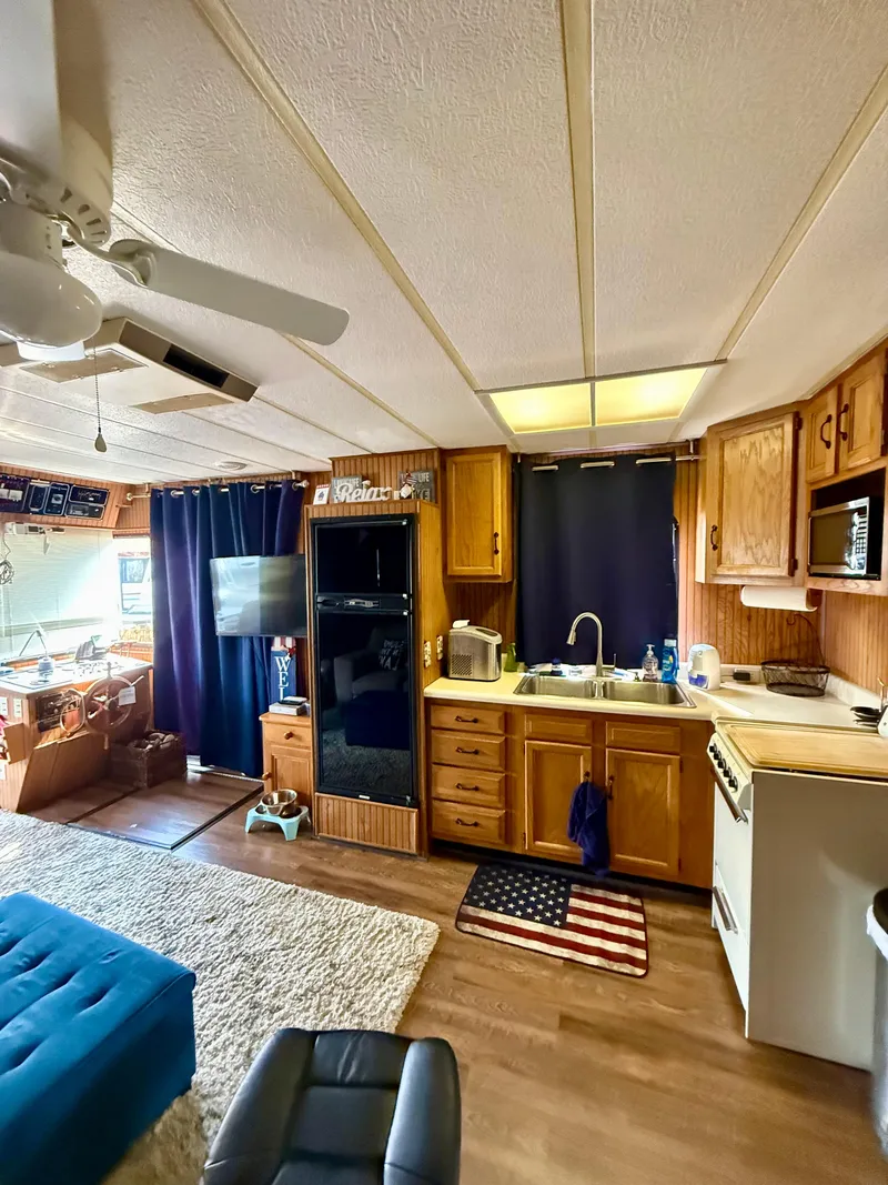 Slide: The Image of Interior of a 1996 Jamestowner houseboat with kitchen and living area. - 7