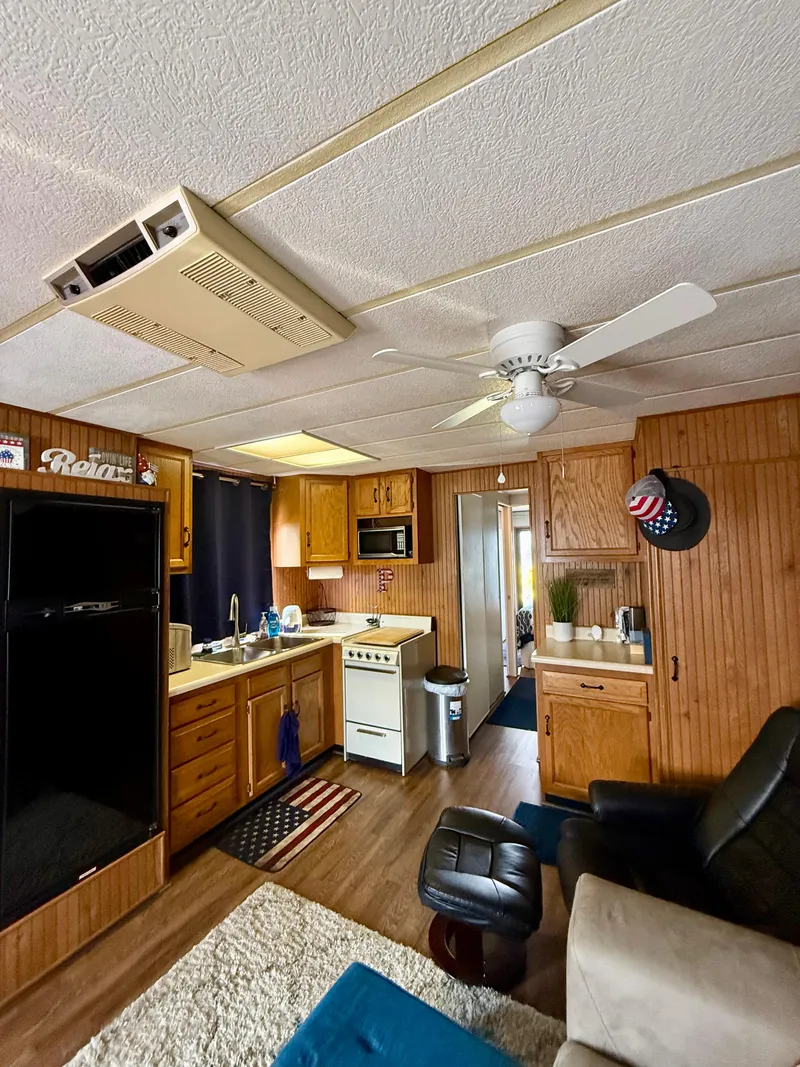 Slide: The Image of Interior of a 1996 Jamestowner houseboat with kitchen and cozy seating area. - 8