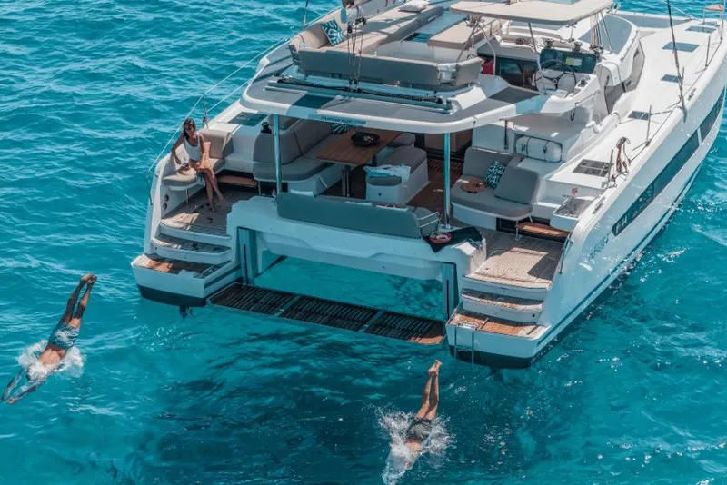 Slide: The Image of 2026 Fountaine Pajot 44 yacht with people diving into clear blue water. - 38