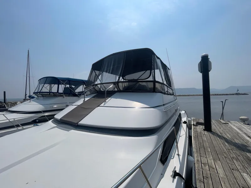 Slide: The Image of 1994 Carver 380 Santego SE yacht docked at a marina under a clear sky. - 11