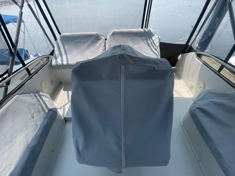 Slide: The Image of 1994 Carver 380 Santego SE boat interior with covered seats and clear windows. - 16