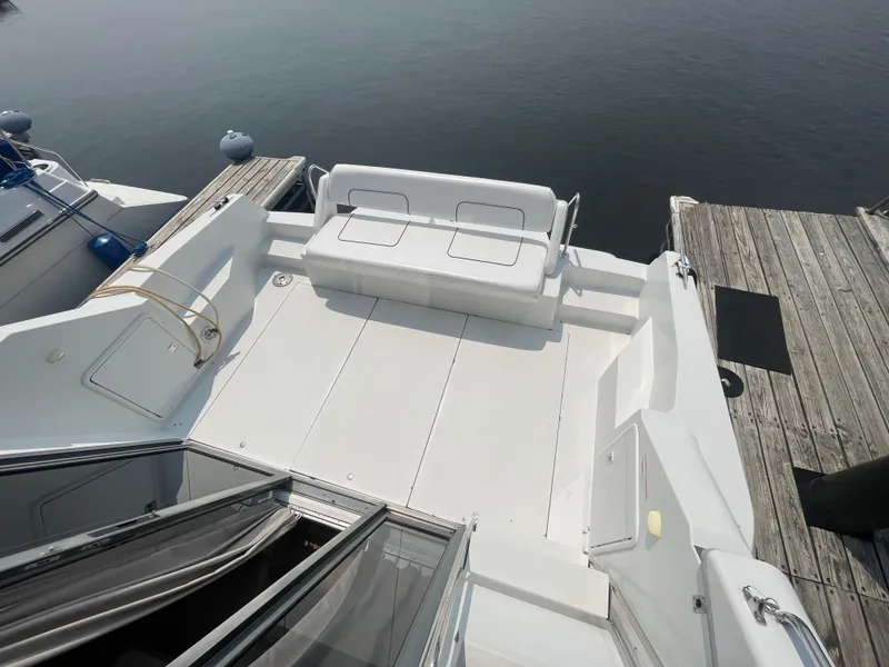 Slide: The Image of 1994 Carver 380 Santego SE yacht deck with seating, docked by calm water. - 18