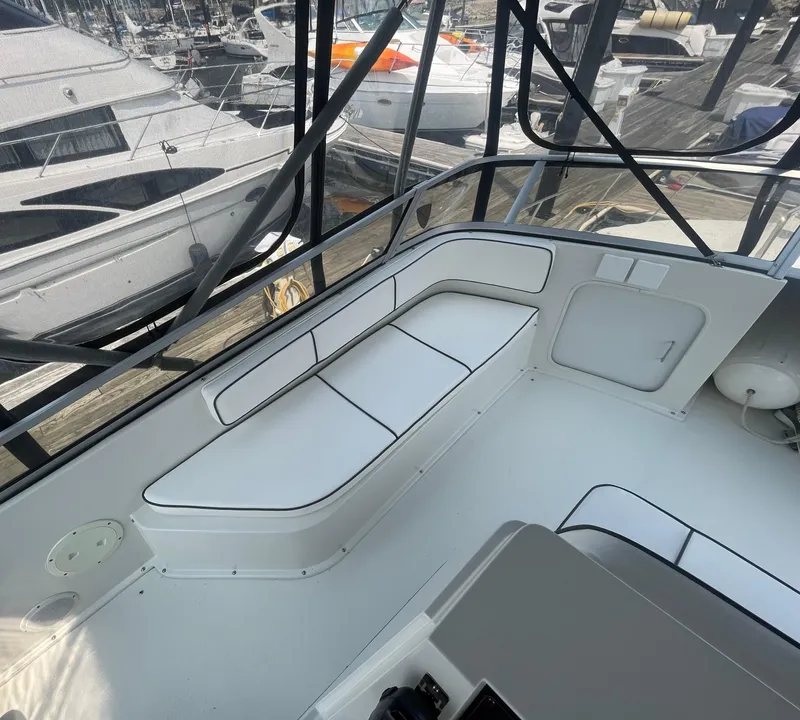 Slide: The Image of 1994 Carver 380 Santego SE boat interior with white seating and marina view. - 20