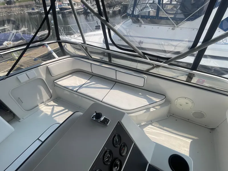 Slide: The Image of 1994 Carver 380 Santego SE boat interior with seating and control panel, docked at marina. - 26