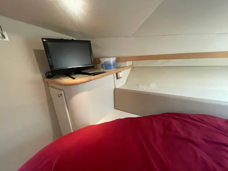 Slide: The Image of 1994 Carver 380 Santego SE cabin interior with TV and red bedding. - 44