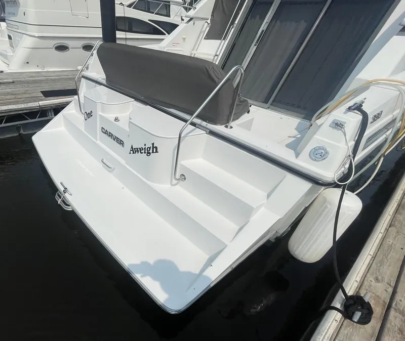 Slide: The Image of 1994 Carver 380 Santego SE yacht docked, featuring a white exterior and rear deck. - 6
