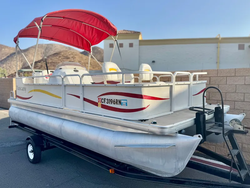 Slide: The Image of 2006 Godfrey Tuscany 2080 pontoon boat with red canopy on trailer, parked outdoors. - 1