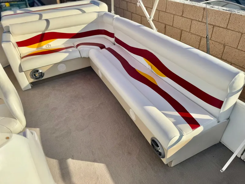 Slide: The Image of 2006 Godfrey Tuscany 2080 boat interior with colorful seating and built-in speakers. - 13