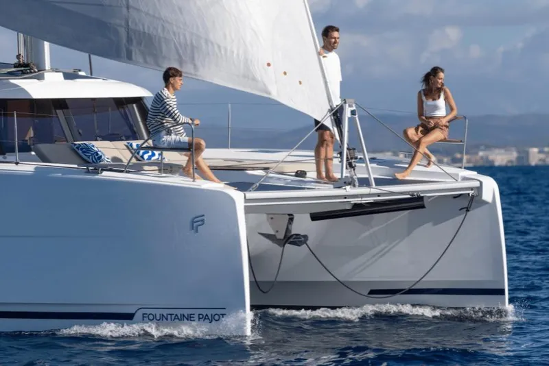 Slide: The Image of 2026 Fountaine Pajot 44 catamaran sailing with three people on deck in open sea. - 5