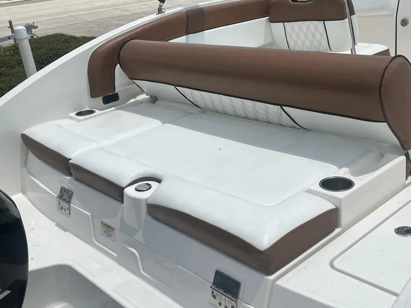Slide: The Image of 2022 Bayliner DX 2200 boat interior with brown and white seating, cup holders visible. - 13