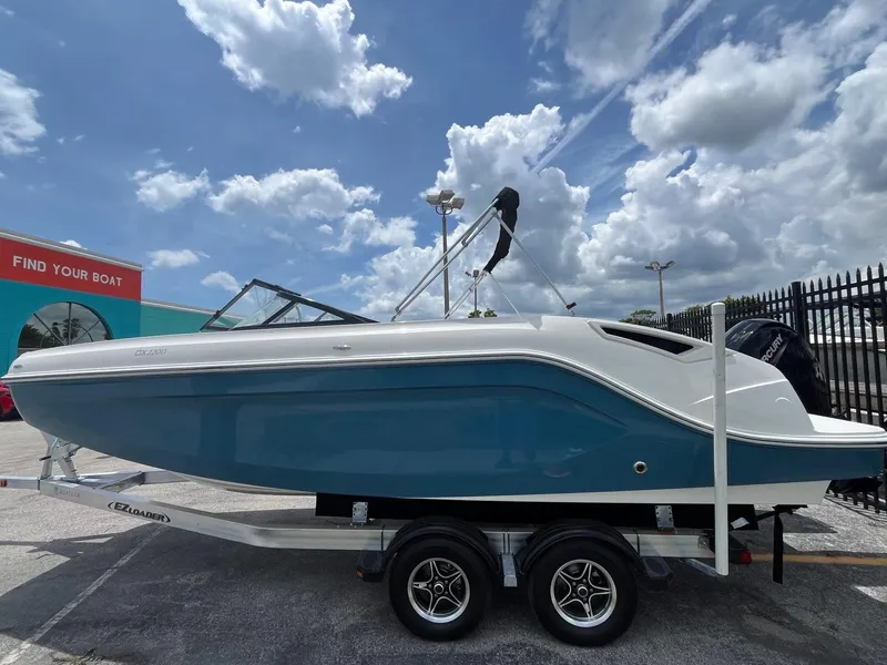 Slide: The Image of 2022 Bayliner DX 2200 boat on trailer under cloudy sky. - 3