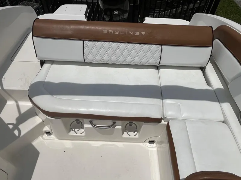 Slide: The Image of 2022 Bayliner DX 2200 boat seating with white and brown upholstery. - 5